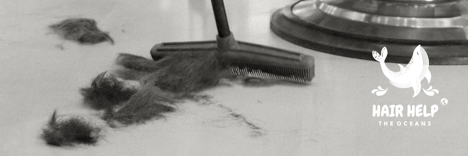 Schwarz-weißes Bild von abgeschnittenen Haaren auf einem Friseurboden, die mit einem Besen zusammengefegt werden. Rechts unten ist das Logo von ‚Hair Help The Oceans‘ mit einem stilisierten Wal zu sehen
