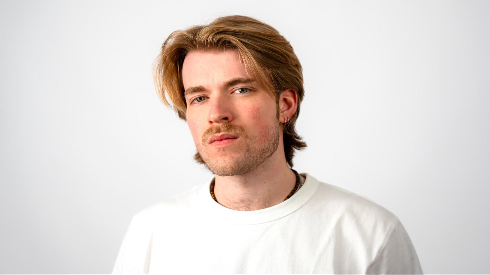 Mann mit modernem blondem Mittelscheitel. 